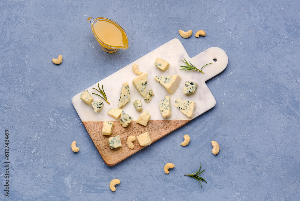 Board with pieces of tasty cheese and honey on grey background