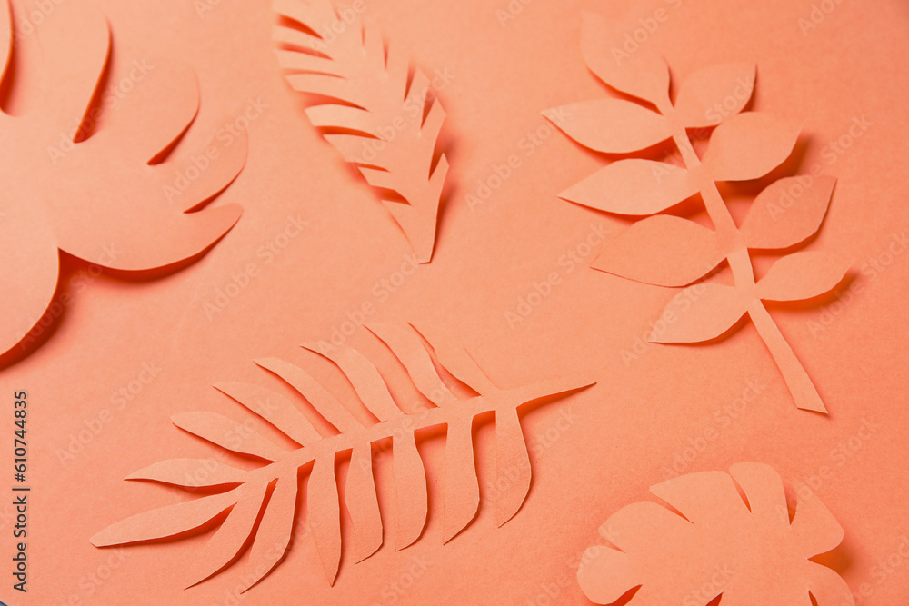 Beautiful origami leaves on orange background, closeup