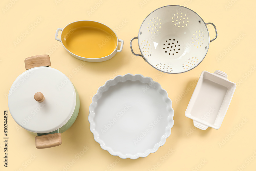 Set of different kitchen utensils on beige background