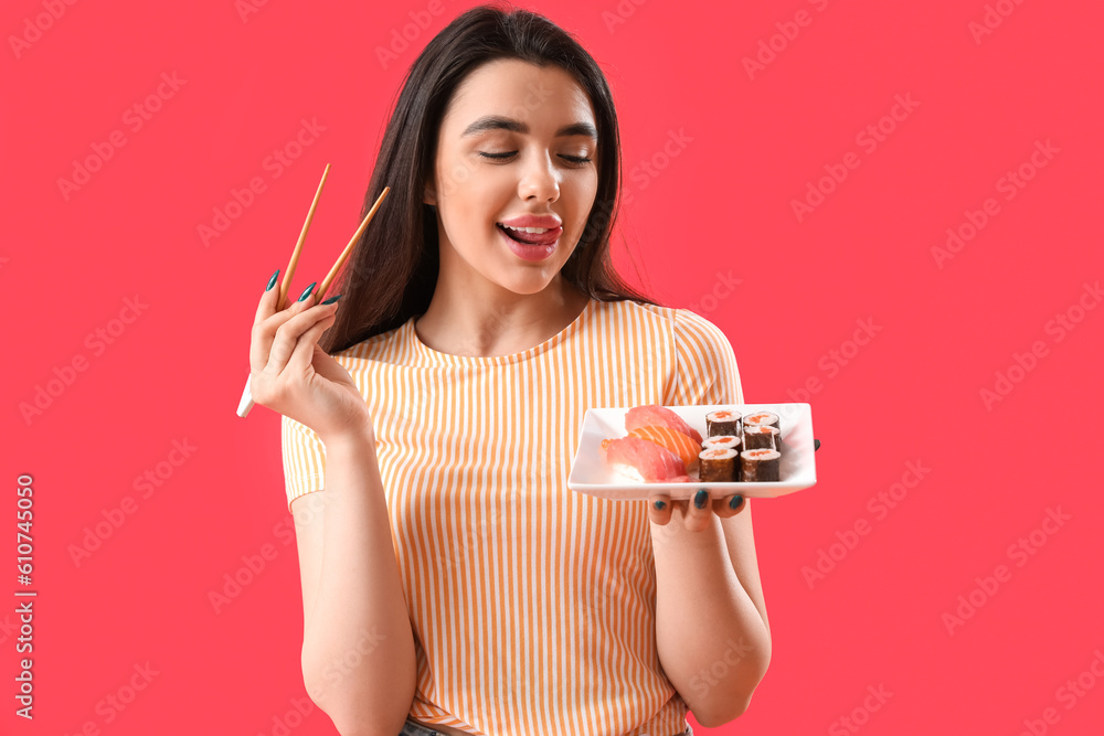 Young woman with sushi rolls and chopsticks on red background