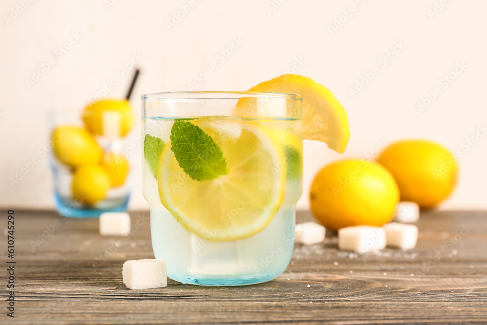 Glass with fresh lemonade on wooden table