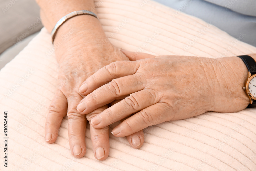 Senior woman with pillow sitting at home, closeup