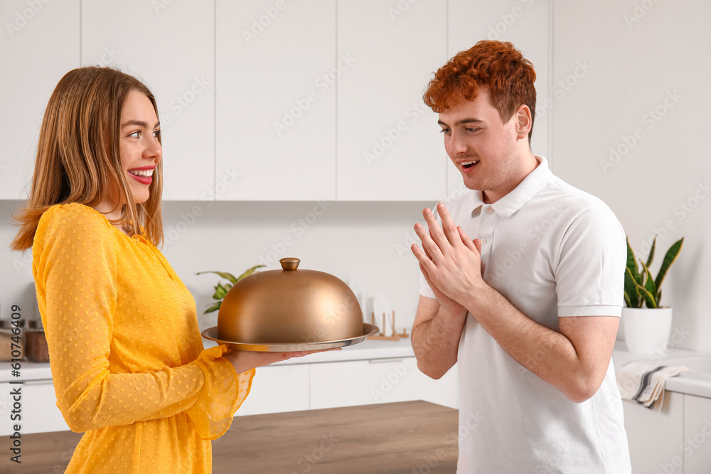 Young woman with cloche proposing to her boyfriend in kitchen