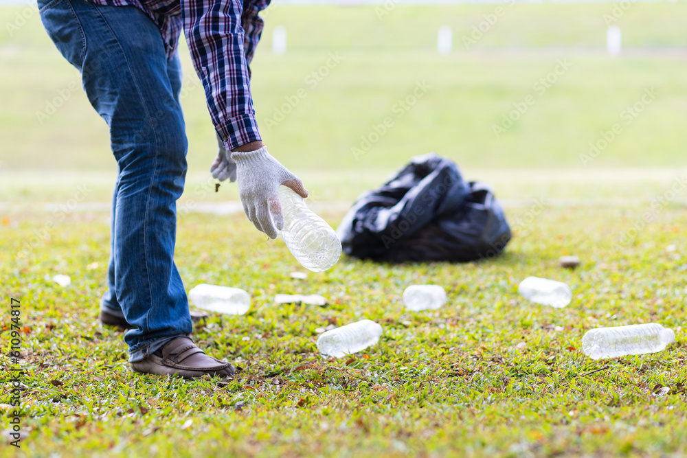 Volunteers picking up plastic bottles on the parks lawn.