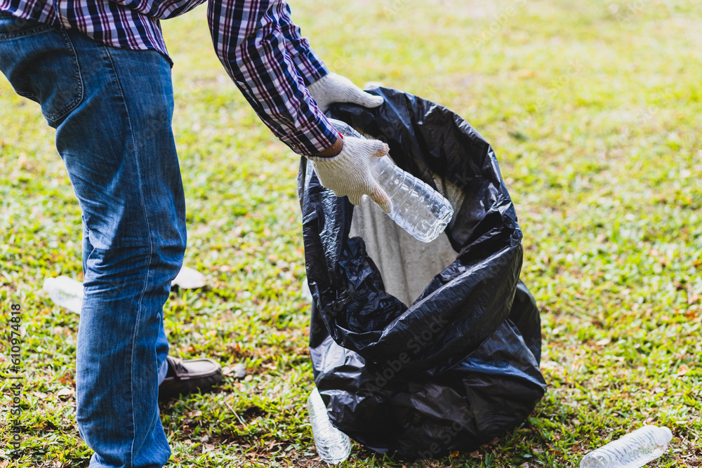 Volunteers picking up plastic bottles on the parks lawn.