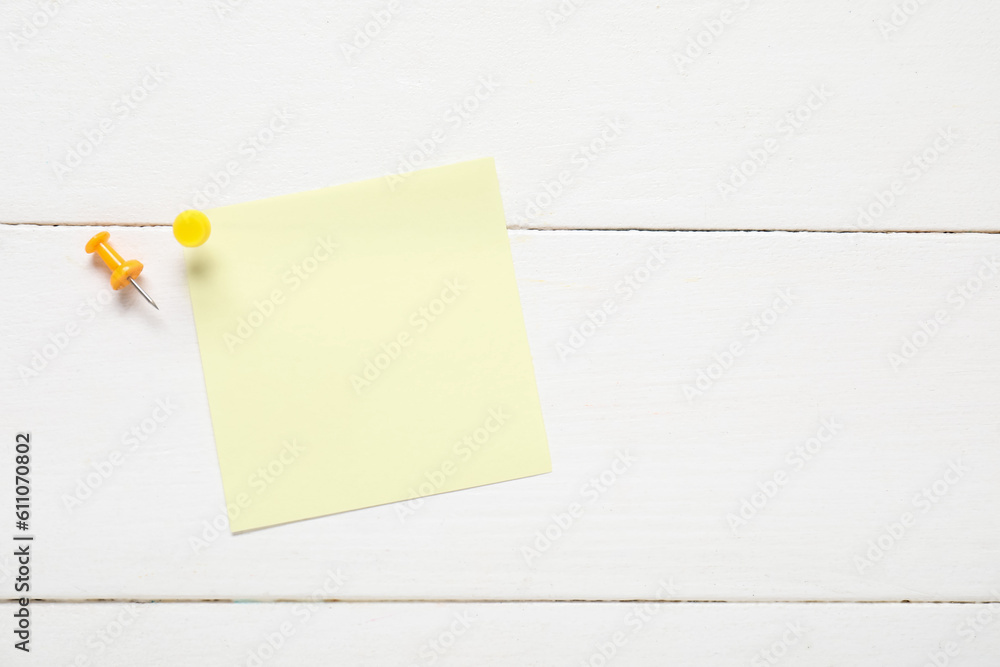 Sticky notes with pins on white wooden background