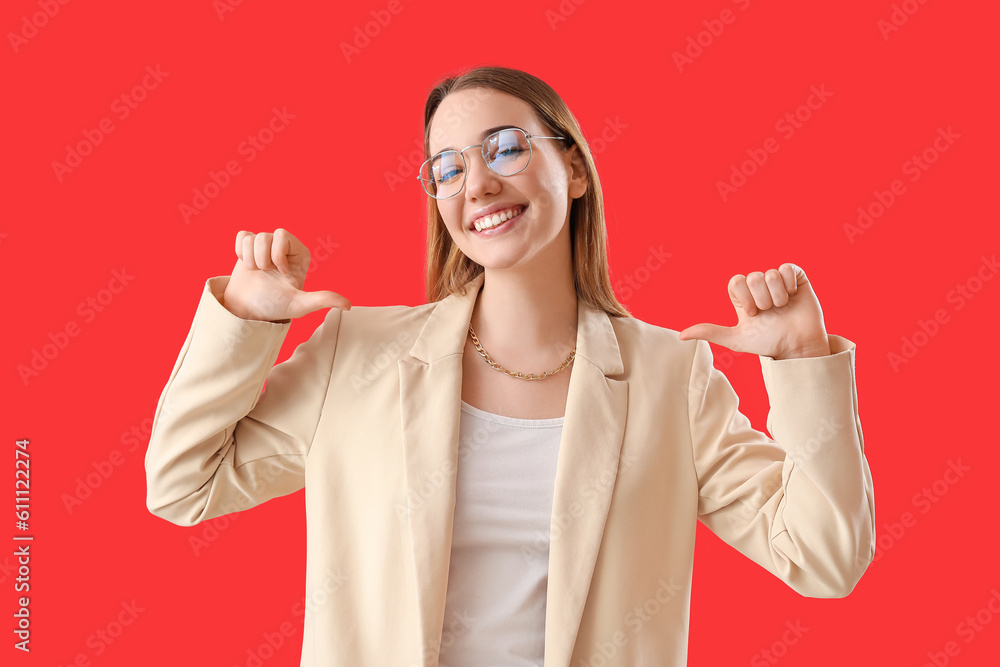 Young businesswoman pointing at herself on red background