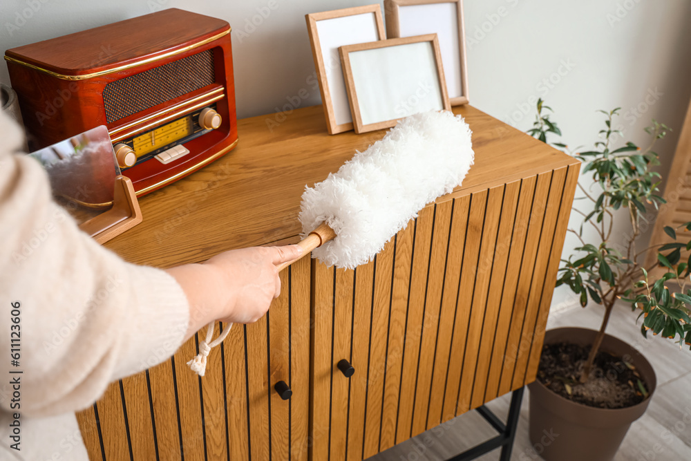 Housewife cleaning table with pp-duster at home, closeup