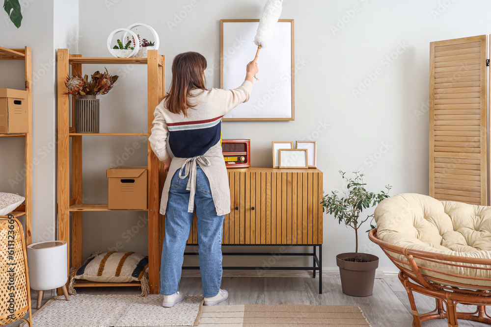 Housewife cleaning blank frame with pp-duster at home