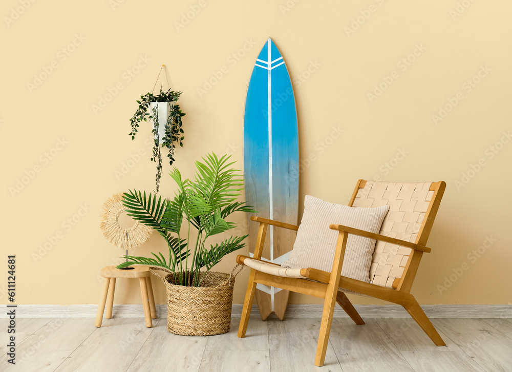 Interior of living room with surfboard, armchair and houseplants