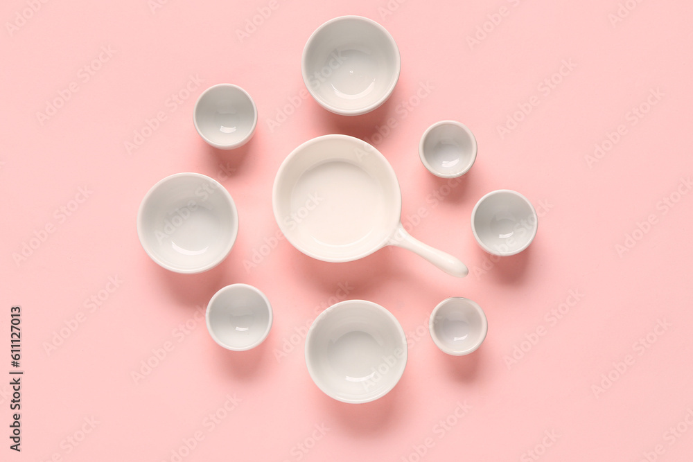 Composition with clean bowls and cup on pink background