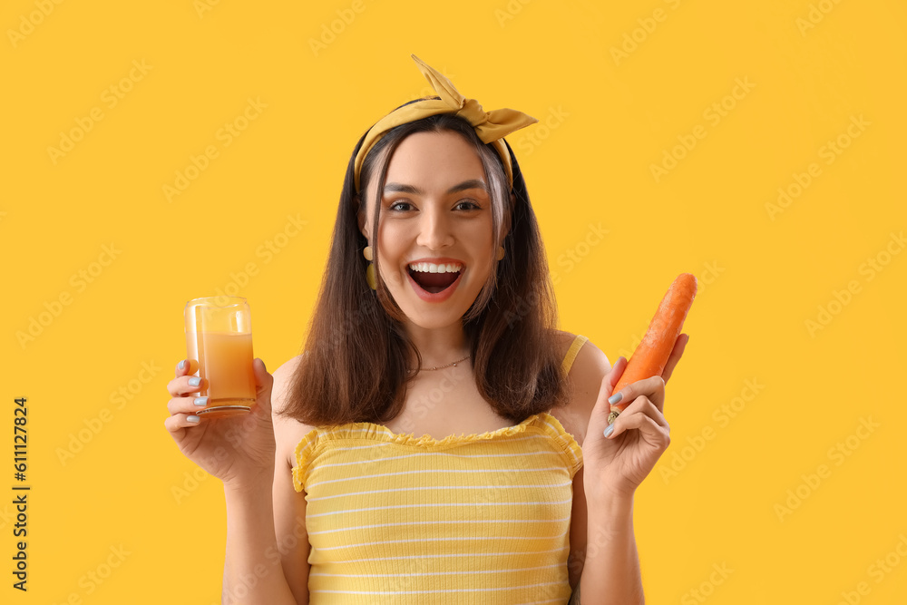 Young woman with glass of vegetable juice and carrot on yellow background