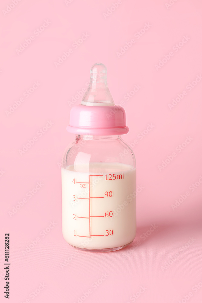 Bottle of milk for baby on pink background