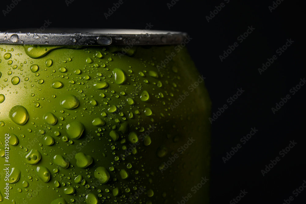 Green can of fresh soda with water drops on dark background, closeup