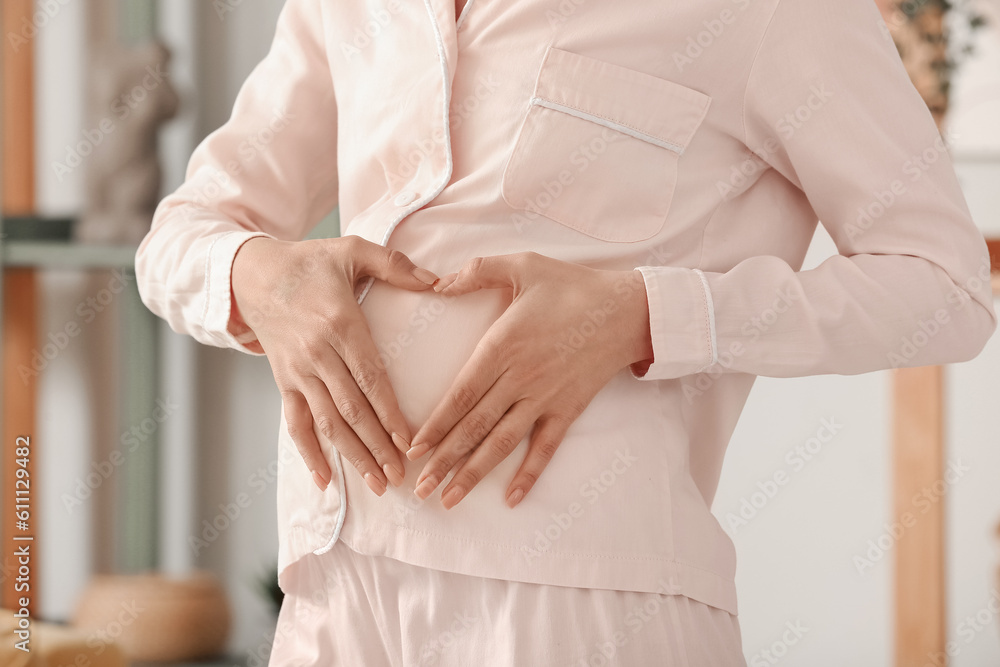 Young pregnant woman in pajamas at home, closeup