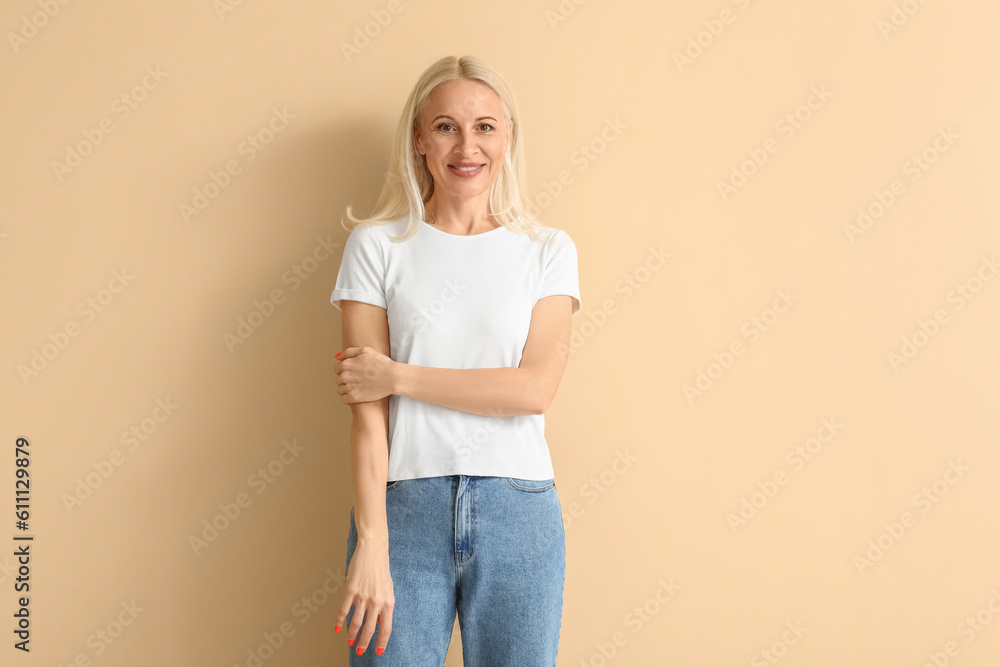 Mature blonde woman on beige background