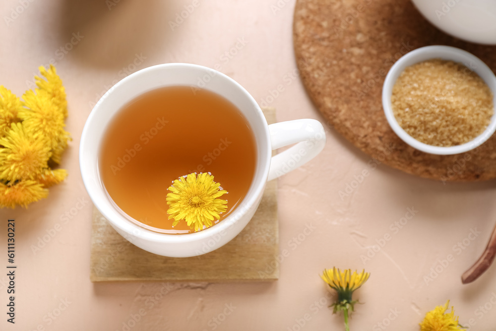 Cup of healthy dandelion tea on beige background