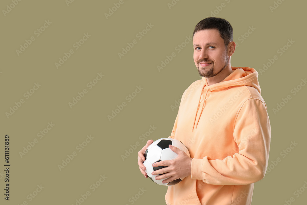 Happy man with soccer ball on color background