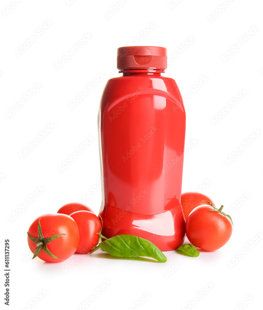 Bottle of ketchup and tomatoes on white background