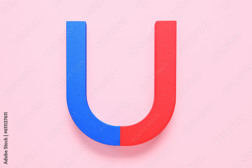 Horseshoe shaped magnet on pink background