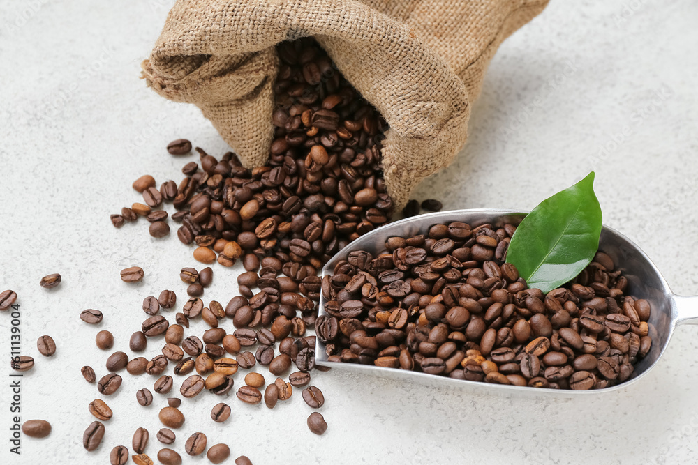 Sack bag and scoop with coffee beans on light background