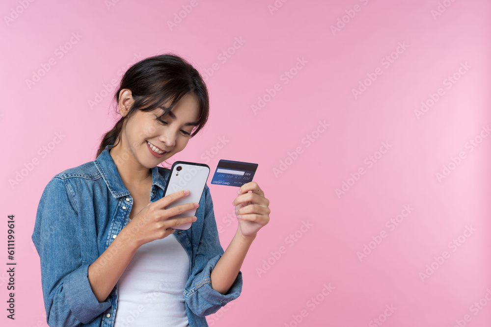 Young beauty Asian woman shopping payment online with credit card on smartphone and she wearing jean