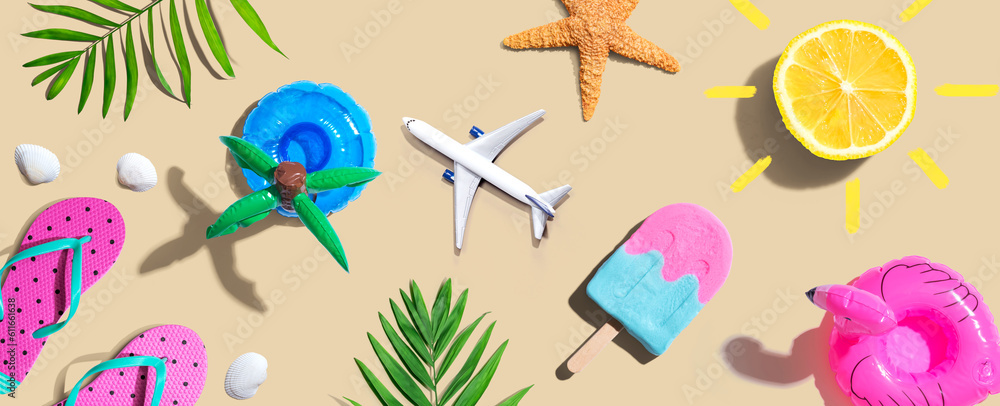 Summer concept with a airplane, a popsicle, flip flops and lemon sunshine - flat lay