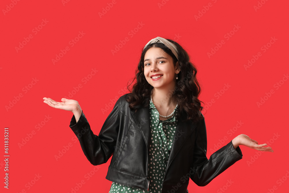 Teenage girl in leather jacket on red background