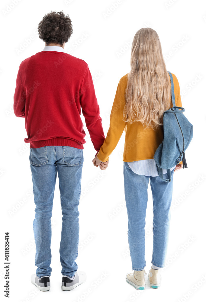 Teenage couple holding hands on white background, back view