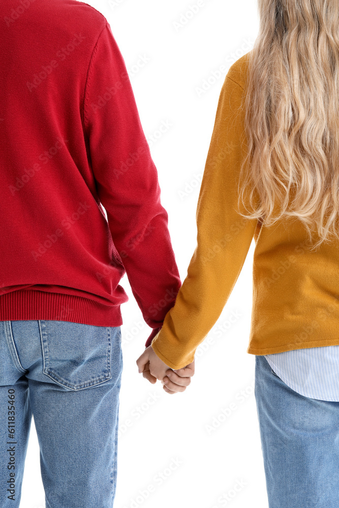 Teenage couple holding hands on white background, back view