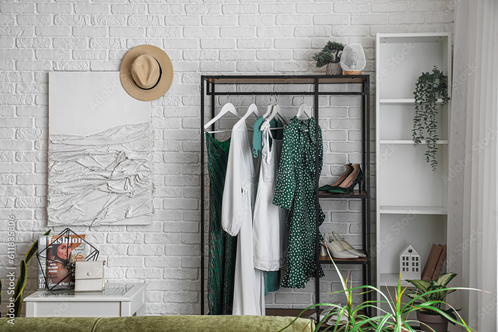 Shelving unit with clothes in interior of light room