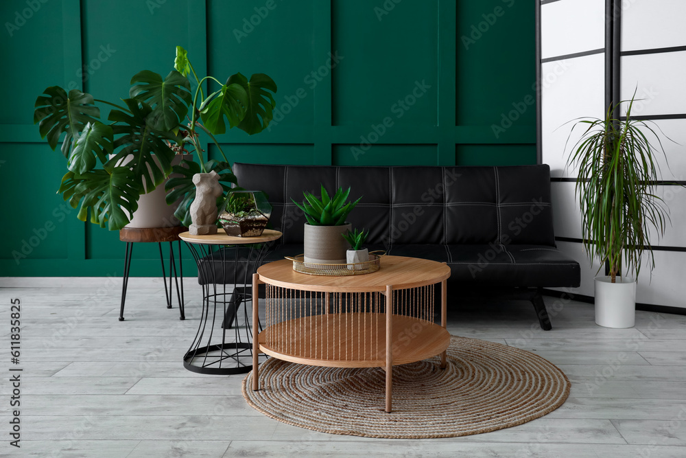 Interior of living room with coffee tables, houseplants and sofa