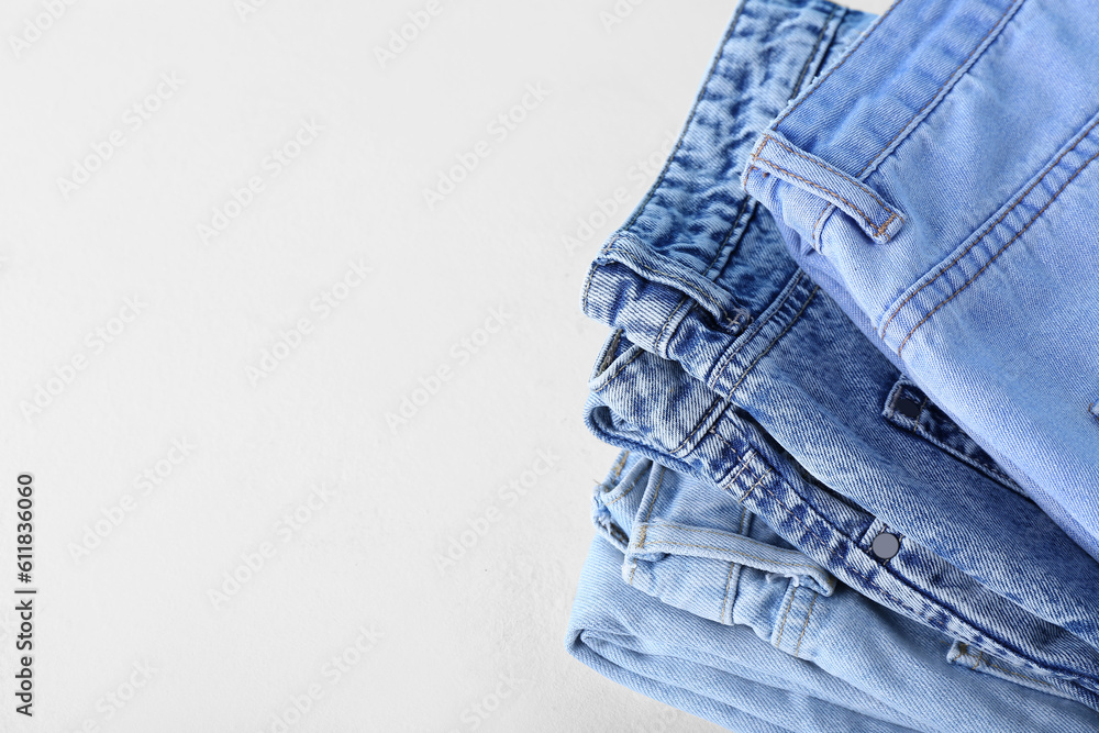 Folded jeans on white background, closeup