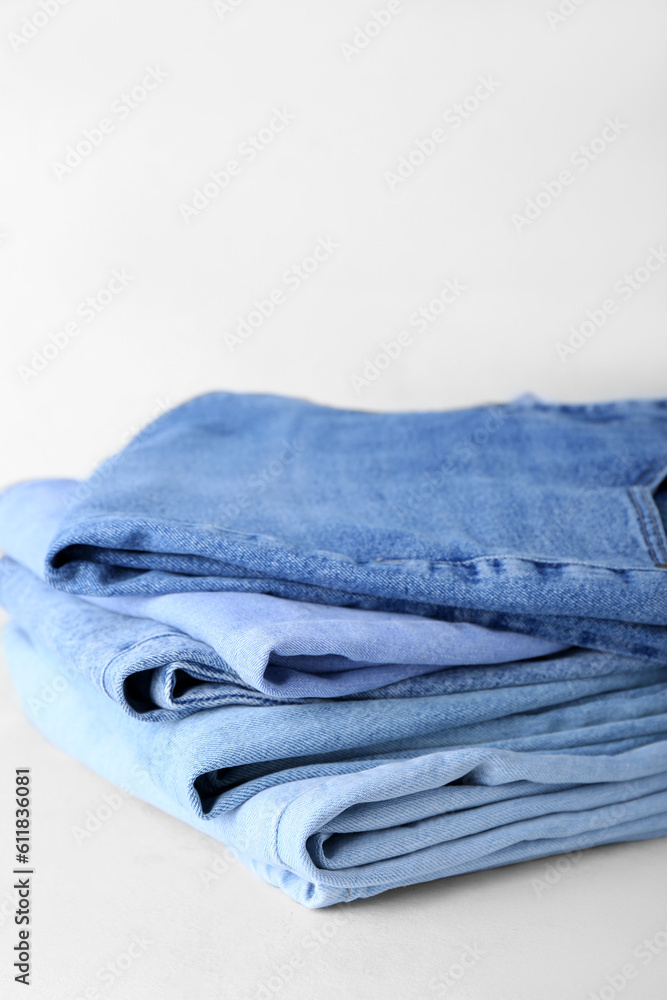 Stack of jeans on white background, closeup