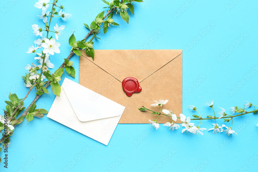 Blooming tree branches with white flowers and envelopes on blue background