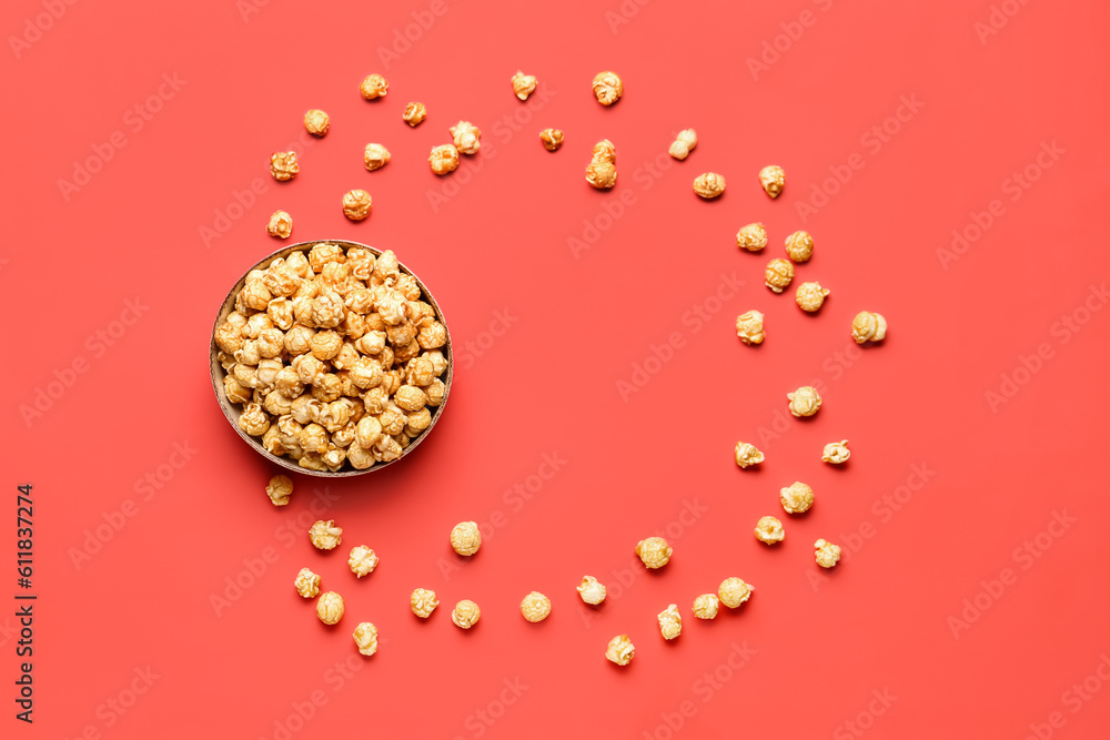 Bowl with crispy popcorn on red background