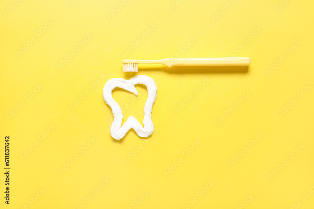 Tooth made of white paste with brush on yellow background