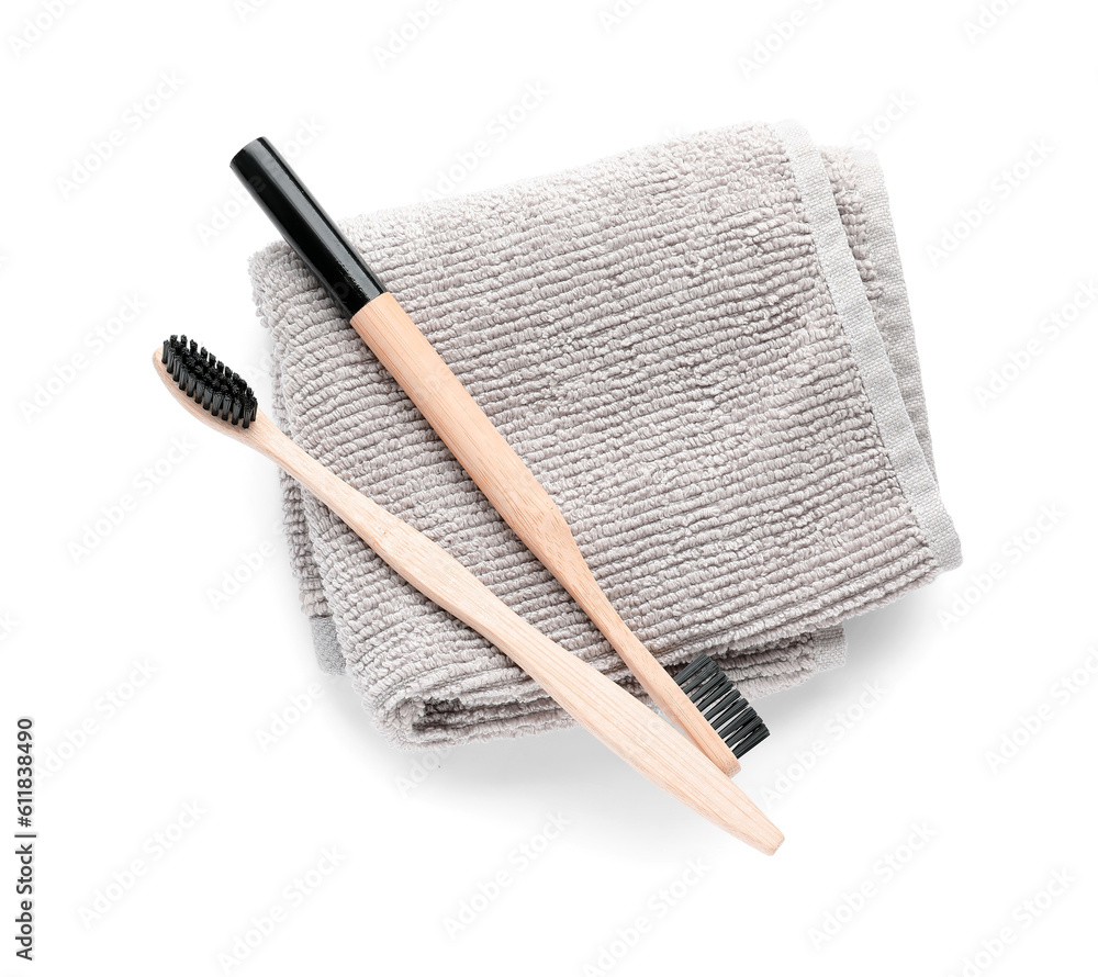 Bamboo toothbrushes with towel on white background