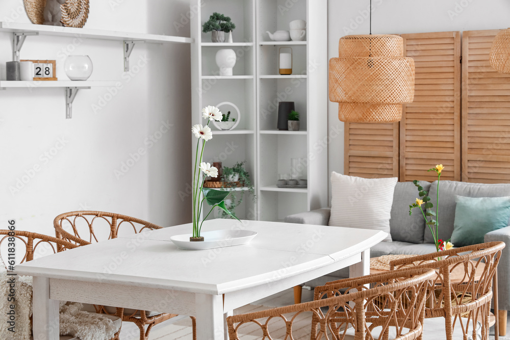 Beautiful ikebana on dining table in room