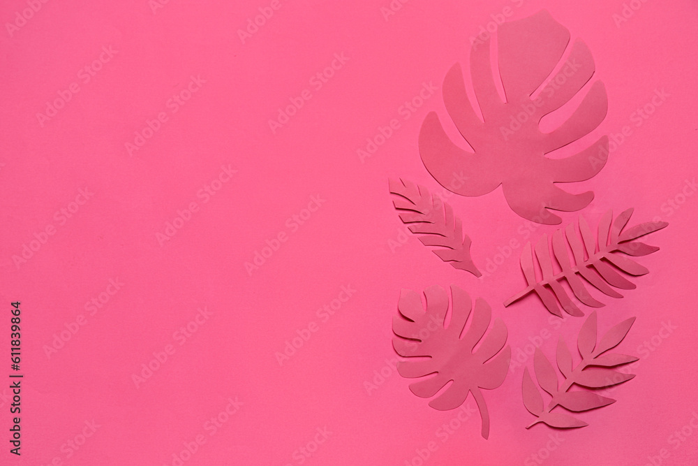 Different paper tropical leaves on pink background