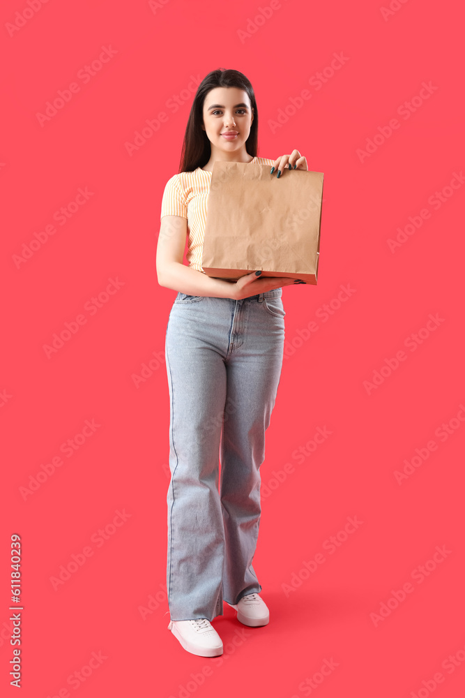 Young woman with paper bag of sushi on red background