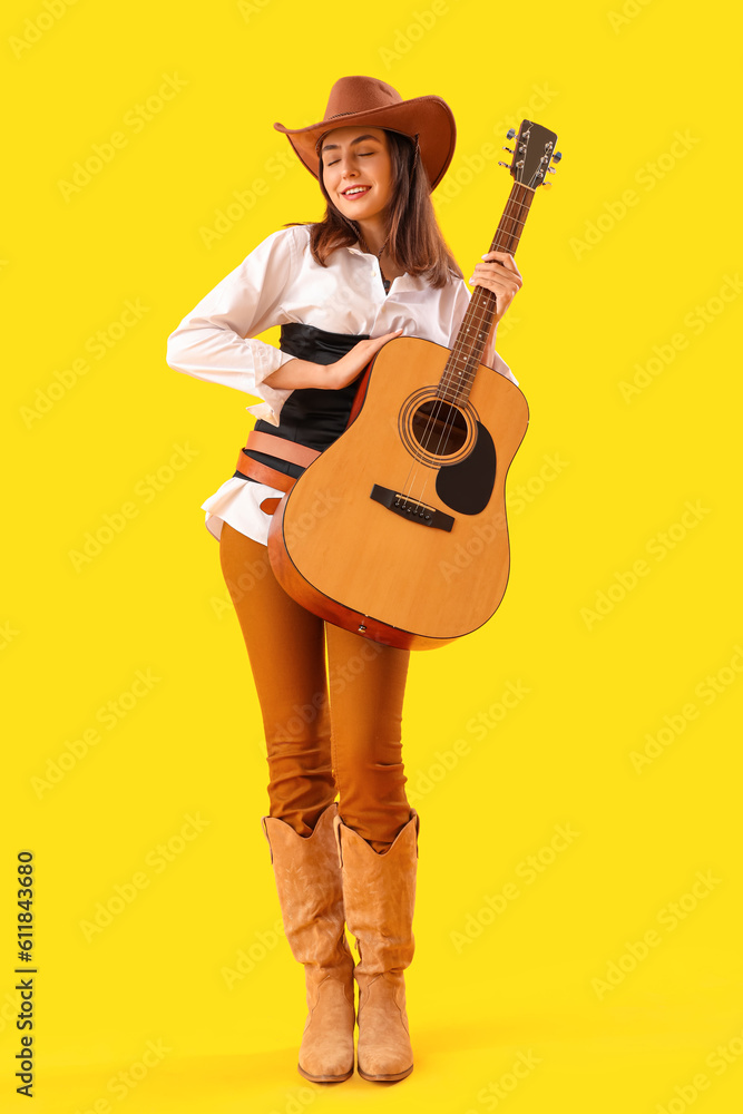 Beautiful cowgirl with guitar on yellow background