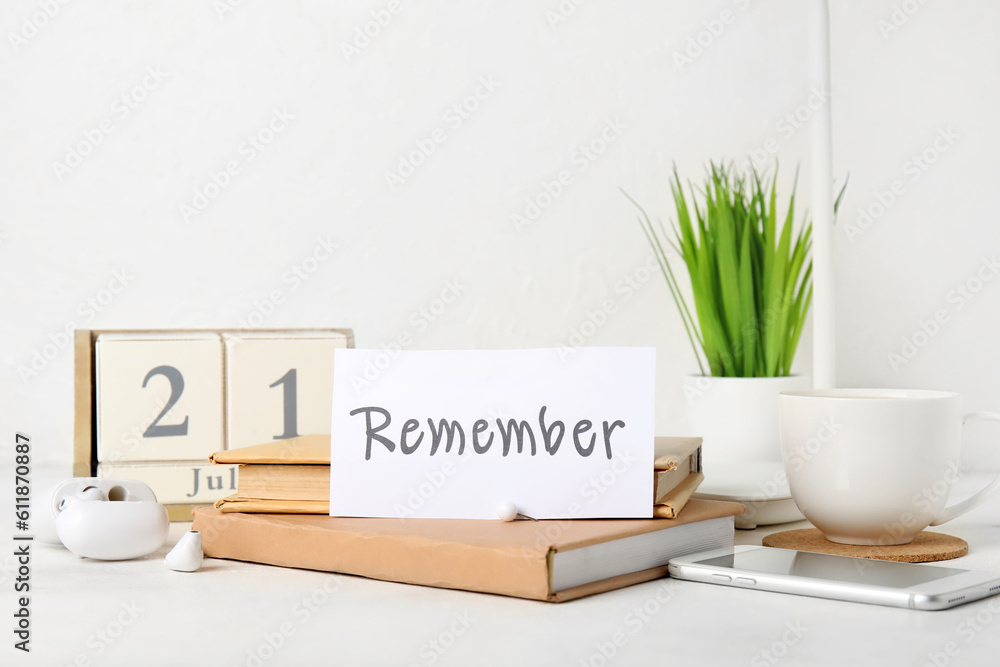 Reminder with books, mobile phone and earphones on white table