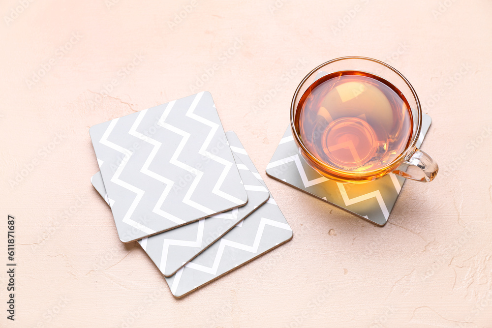 Drink coasters with cup of tea on beige table