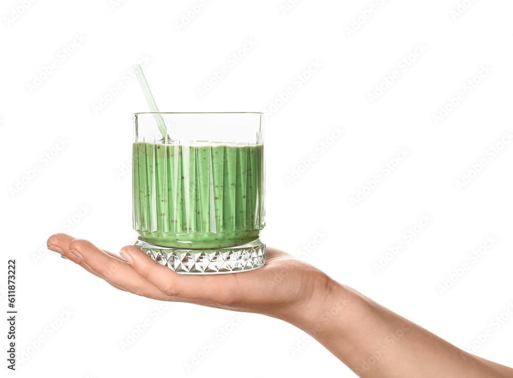 Female hand with glass of green smoothie on white background