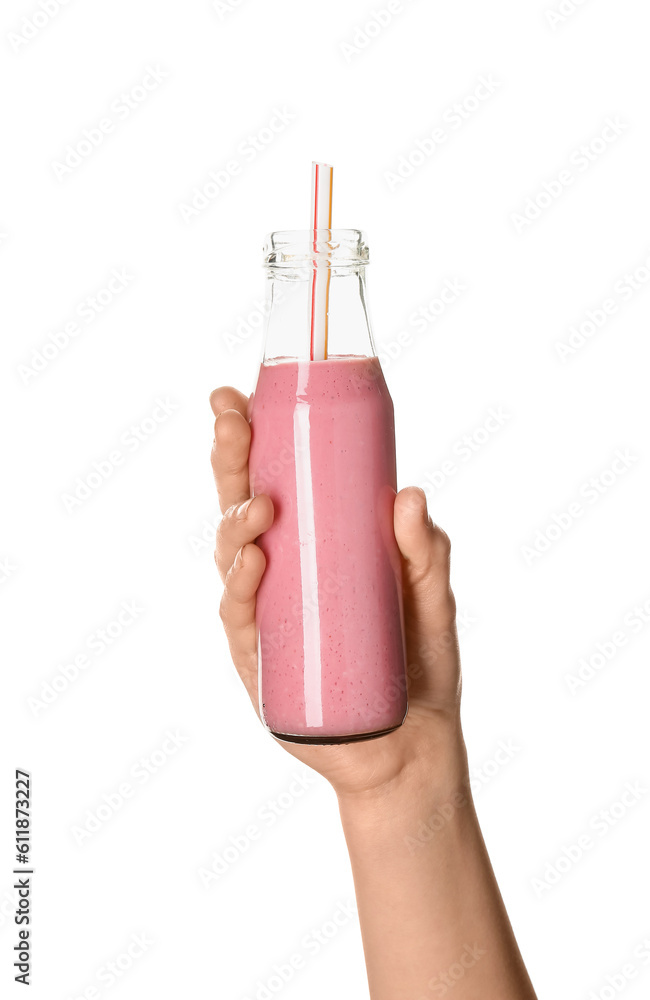 Female hand with glass bottle of pink smoothie on white background