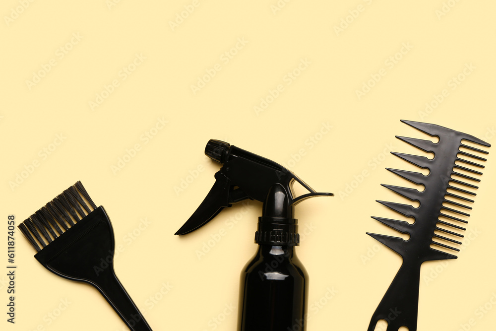 Hairdressers brushes with spray on yellow background