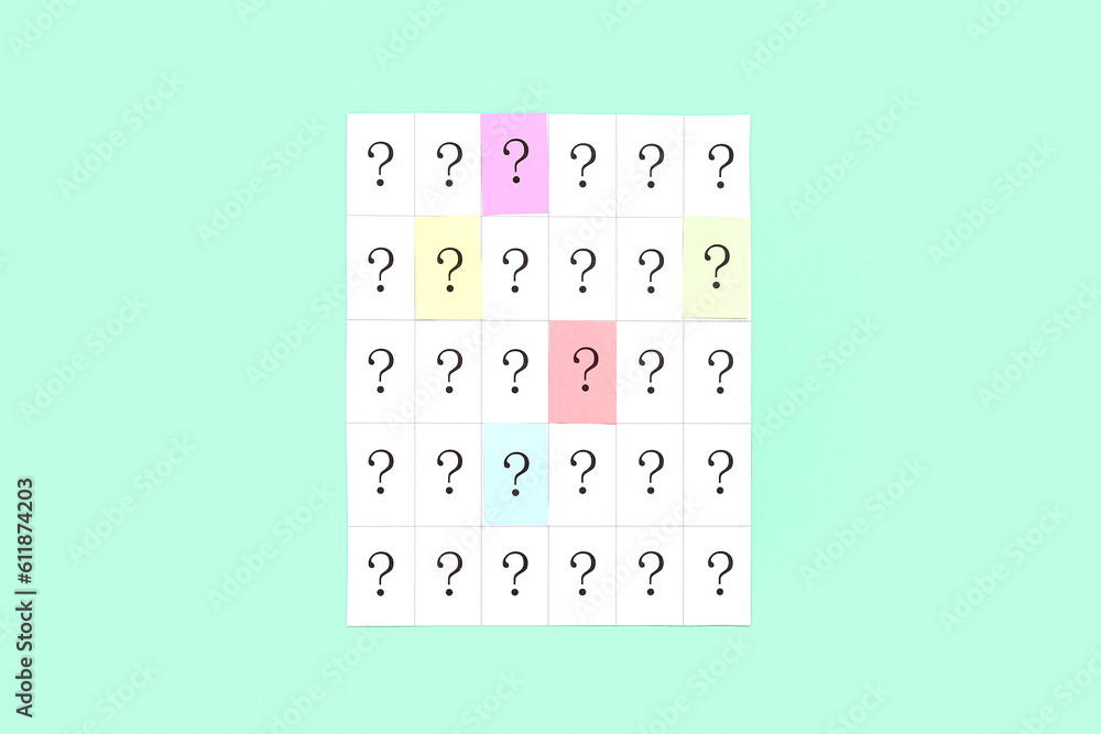 Paper with question marks on green background