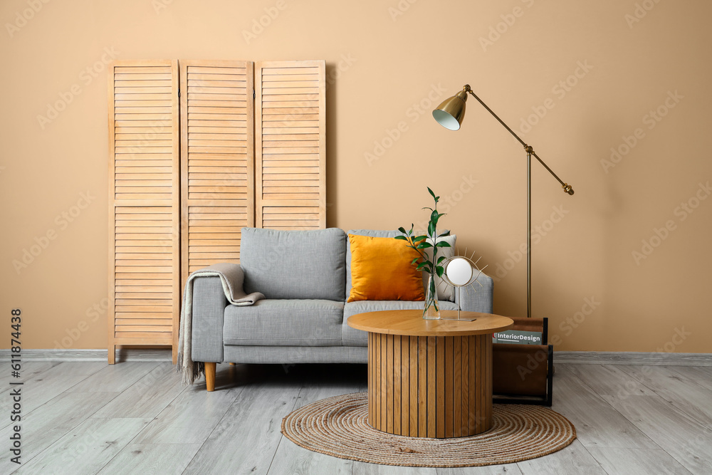 Interior of living room with grey sofa, coffee table and folding screen