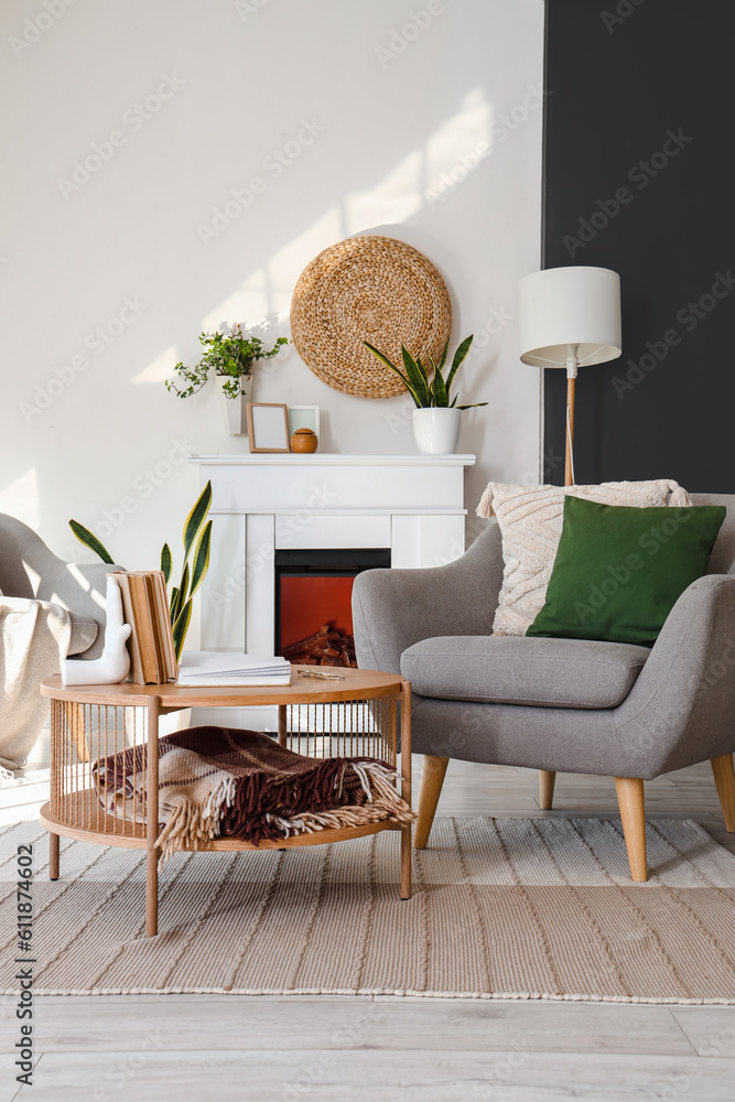 Interior of bright living room with armchairs, coffee table and fireplace